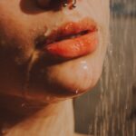 a woman with nose piercings taking a shower