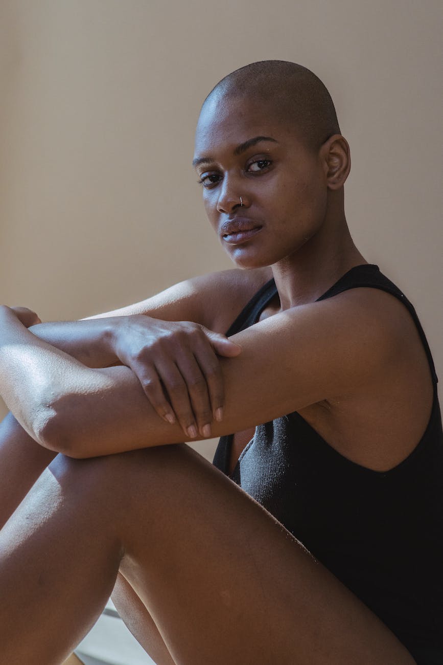 black model with crossed arms and shaved head